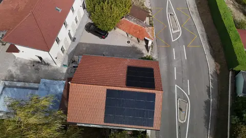 Vue aérienne de deux groupes de panneaux photovoltaïques sur une toiture en tuiles rouges à Maubec (38)
